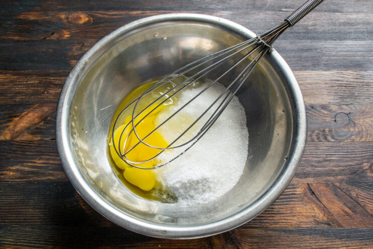 Mixing Ingredients for Muffin Batter in a Bowl A glass bowl containing sugar and an egg, the first step in making muffin batter.