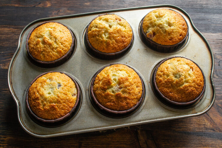 Freshly Baked Carrot and Fig Muffins in the Tin Golden-brown carrot and fig muffins fresh out of the oven, still in the muffin tin.