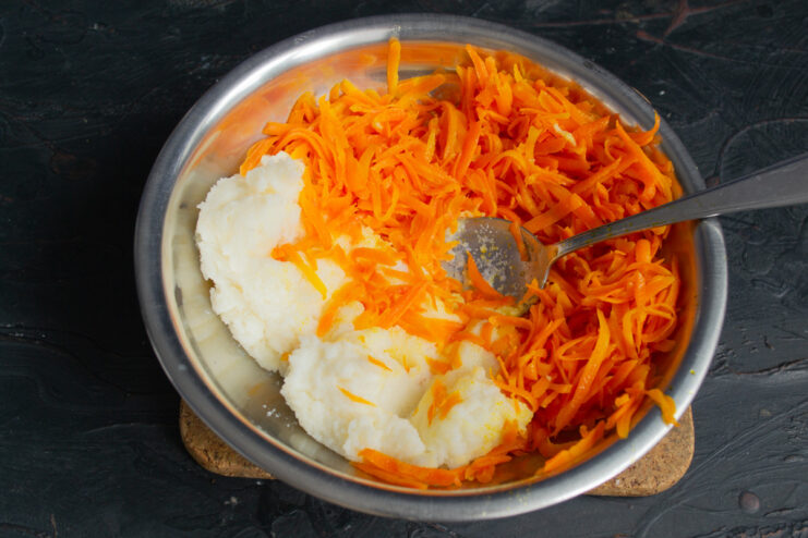 Combining cooked semolina porridge and sautéed carrots in a bowl. A bowl containing a mixture of cooked semolina porridge and sautéed carrots.