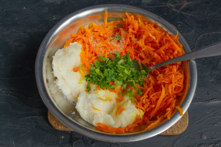 Adding fresh parsley to the carrot and semolina mixture. Adding finely chopped fresh parsley to the carrot and semolina mixture in a bowl.
