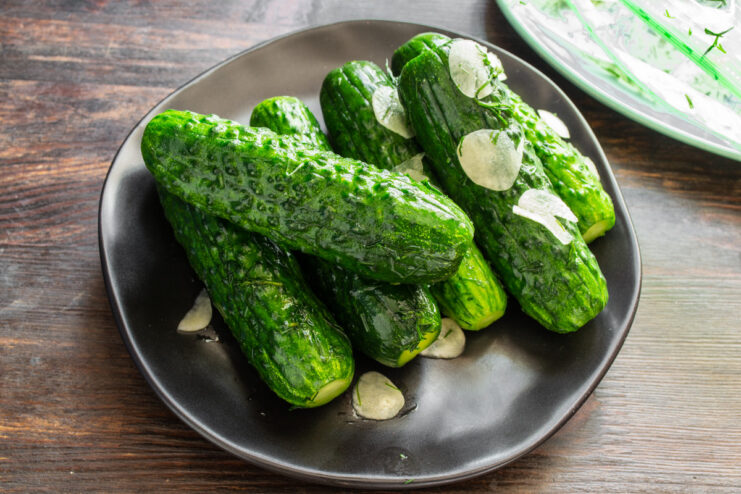The perfect summer meal: crispy pickles with young potatoes. A delicious summer meal featuring quick pickled cucumbers and fried new potatoes served on a plate.