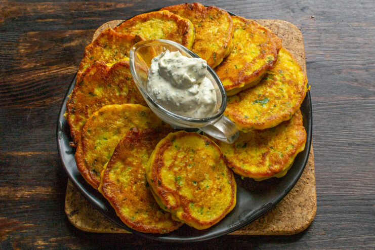 Serving the Pumpkin Pancakes Hot. Drizzle with the homemade sauce for the best flavor. A stack of freshly made pumpkin pancakes on a plate, generously drizzled with a creamy yellow sauce and garnished with dill.