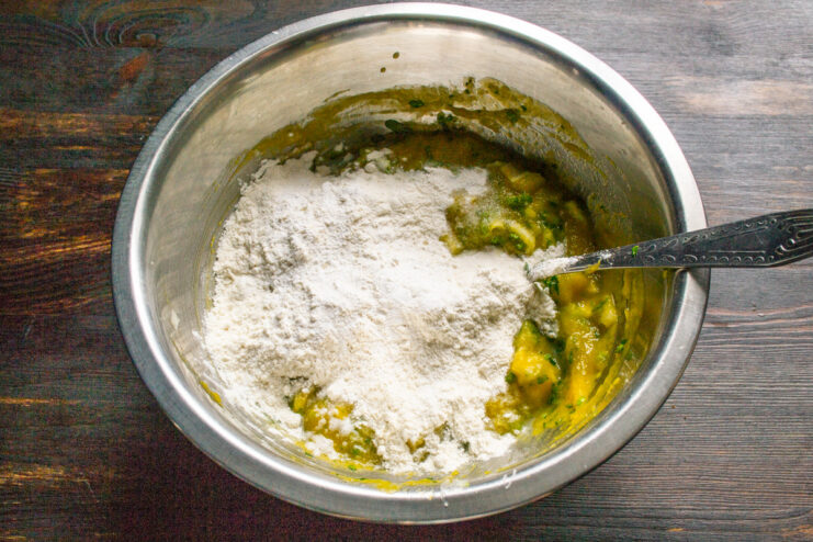 Combining Wet and Dry Ingredients. Mix until just combined to keep the pancakes tender. Flour being added to the bowl with the pumpkin, egg, and herb mixture.