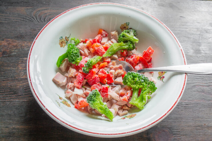 Adding Fresh Broccoli to the Omelet Mix A bowl containing diced ham, red pepper, and fresh broccoli florets.