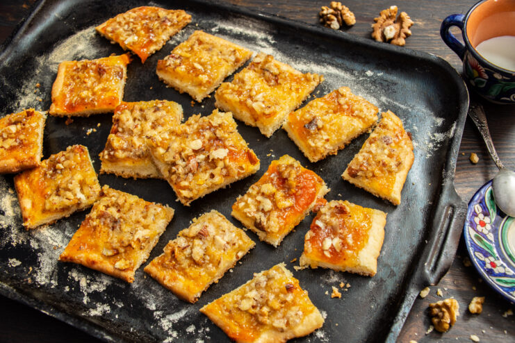 A plate of freshly baked nut cookies with apricot jam, cut into squares.