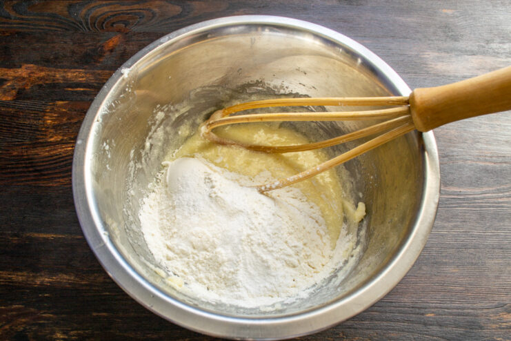 Sifting dry ingredients for the cookie dough Sifting flour and baking powder into a bowl with the wet ingredients.