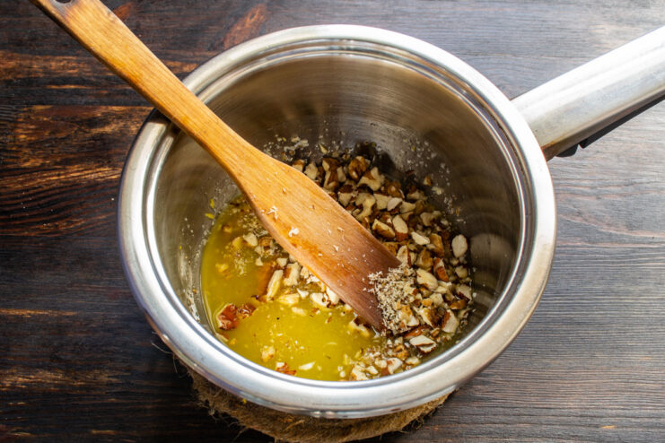 Preparing the nuts for the cookie topping A pile of chopped walnuts and almonds on a cutting board.
