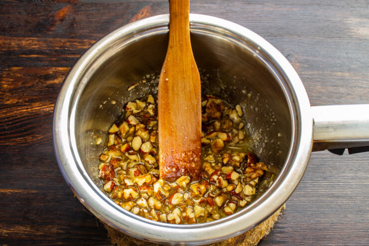Making the caramelized nut filling in a saucepan Melting sugar with butter and nuts in a saucepan for the cookie topping.