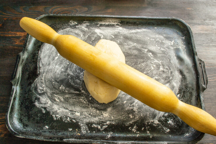 Rolling out the dough directly on the baking sheet Rolling out the cookie dough into a rectangle on a baking sheet.