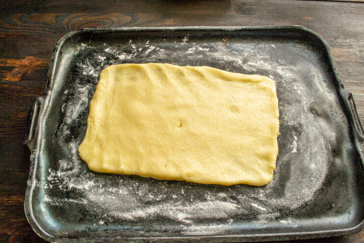 Shaping the rolled-out dough into a rectangle The cookie dough rolled out into a neat rectangle on a baking sheet.