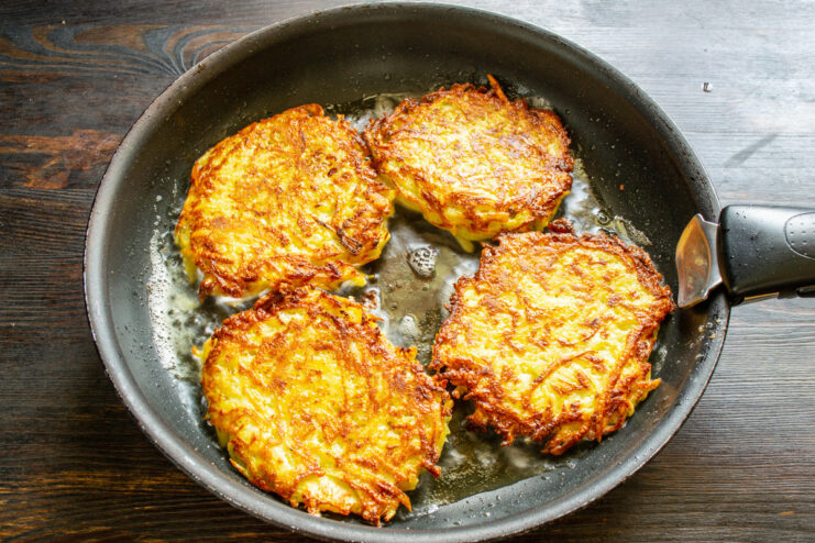 How to Get Crispy Vegetable Fritters Golden-brown vegetable fritters frying in a skillet with hot oil.