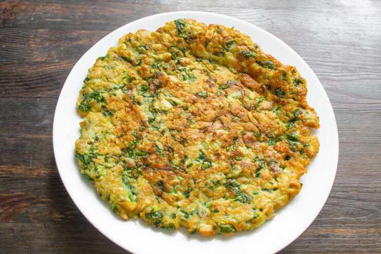 Serving the Warm and Delicious Ovsyanoblin. Enjoy! The finished ovsyanoblin with mushrooms and spinach served on a plate, ready to eat.