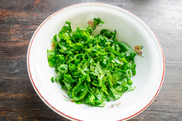 Preparing the Fresh Spinach for the Ovsyanoblin Batter A bowl of freshly chopped spinach for the oatmeal pancake batter.