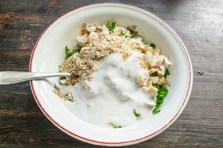 Pouring in Kefir or Yogurt for a Tender Batter Adding kefir or plain yogurt to the ovsyanoblin batter.