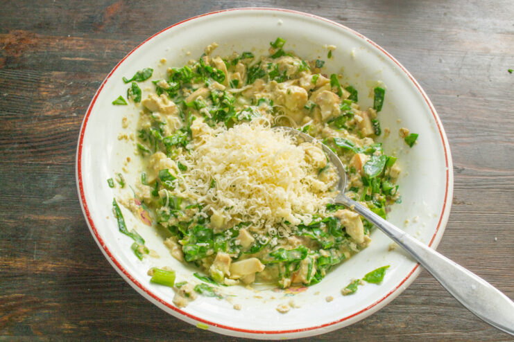Mixing in Grated Cheese for a Savory, Cheesy Flavor Adding grated hard cheese to the ovsyanoblin batter.