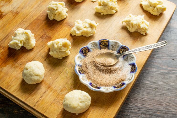 Preparing the cinnamon-sugar coating for the tvorog cookies. A small bowl with a mixture of sugar and ground cinnamon for coating the cookies.