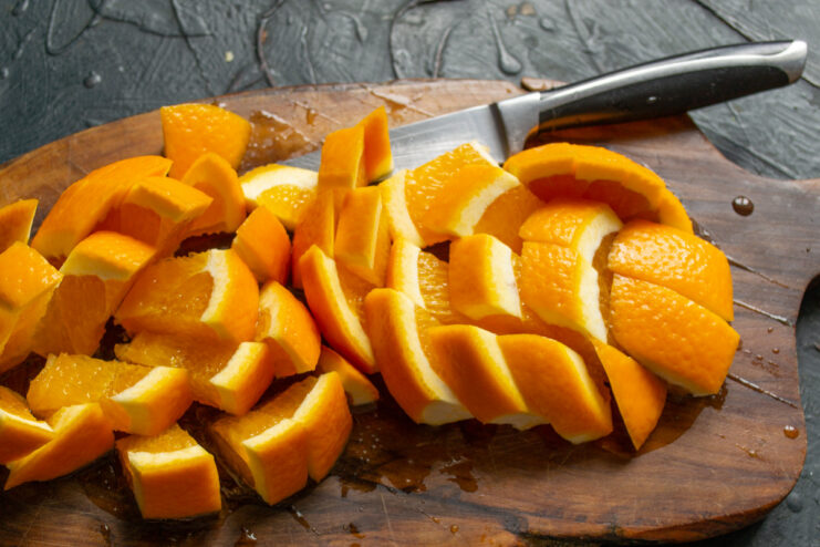 Preparing Oranges for the Marmalade Filling A close-up of a washed orange being diced on a cutting board.
