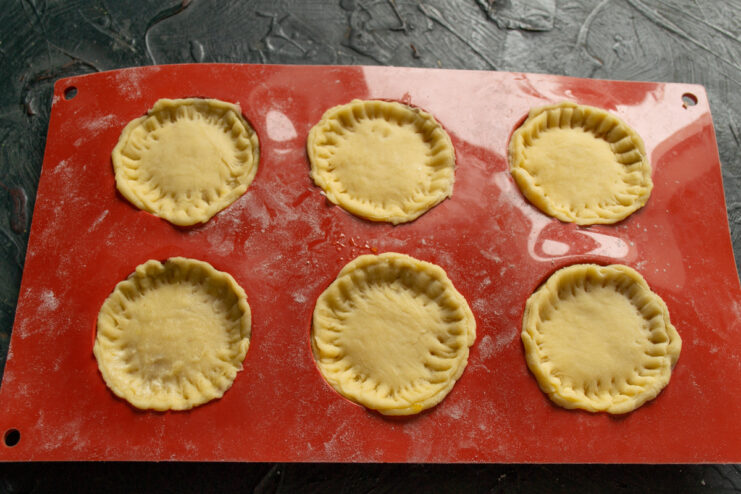 Sealing the Marmalade-Filled Cookies Placing dough lids on the filled cookies and crimping the edges with a fork.