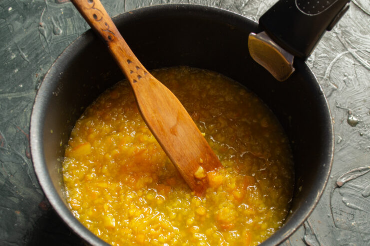 Cooking the Homemade Orange Marmalade Orange puree simmering in a saucepan to make marmalade.