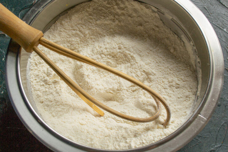Combining Flour, Sugar, and Salt for the Dough Dry ingredients like flour and sugar being mixed in a bowl.