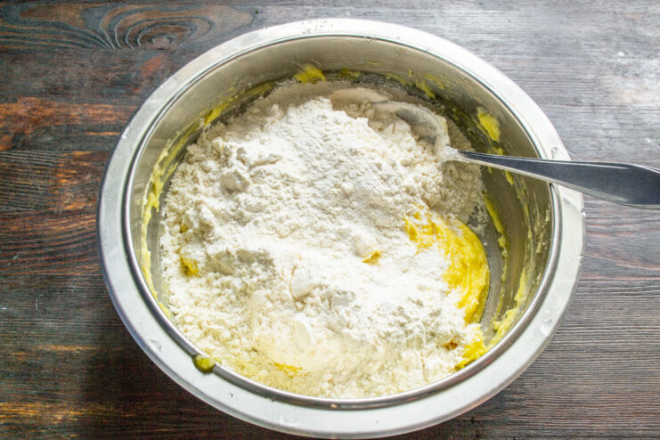 Combining the dry ingredients for the honey poppy seed cookies. Dry ingredients, including flour and baking powder, being mixed in a bowl.