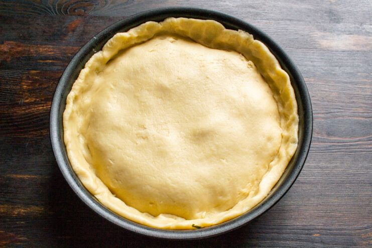 Tucking in the Pastry Edges for a Perfect Pie Tucking the edges of the pastry dough into the skillet around the apple filling.