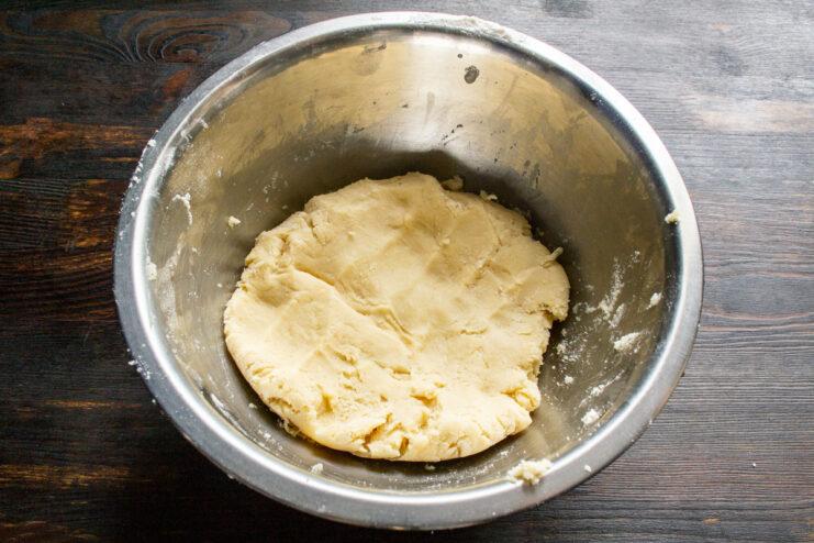 Forming the Pastry Dough for the Apple Pie A ball of freshly made shortcrust pastry dough on a work surface.
