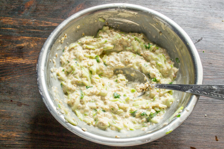 Letting the Zucchini Pizza Batter Rest The prepared zucchini and oat batter resting in a glass bowl.