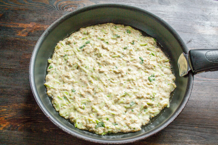 Forming the Zucchini Pizza Crust in the Skillet Spreading the zucchini batter in a non-stick skillet to form a round crust.