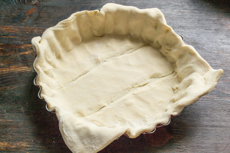 Lining the Baking Pan with Puff Pastry - Pressing the dough into the pan and trimming the excess. Pressing a sheet of puff pastry into a shaped baking pan and trimming the edges.