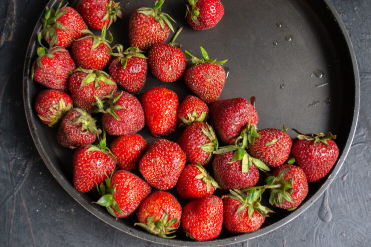 Freshly washed and hulled strawberries in a bowl, ready for the pie filling.