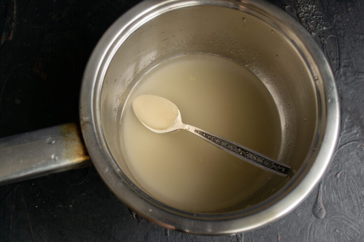A mixture of agar-agar powder and water being heated in a small saucepan.