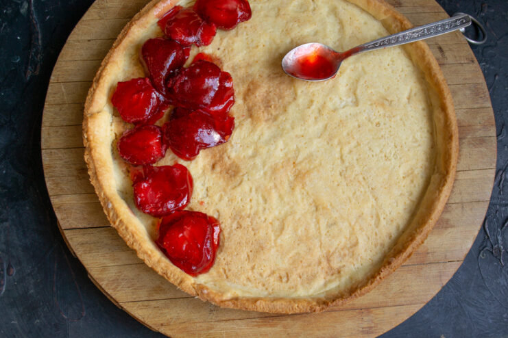 The finished strawberry and agar-agar filling being poured into the baked tart shell.