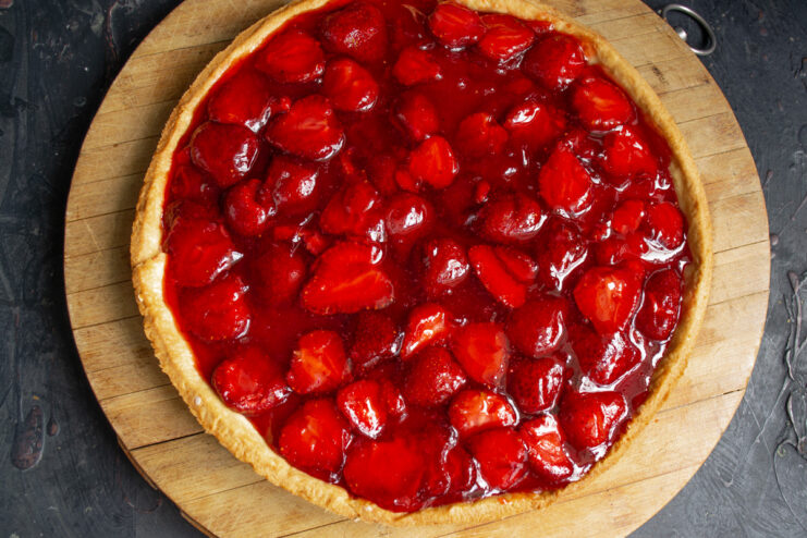 A slice of the finished strawberry pie on a plate, showing the crisp crust and set jelly filling.