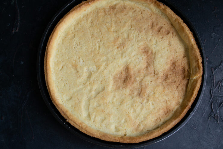 The tart shell, covered with foil and weights, baking in the oven.