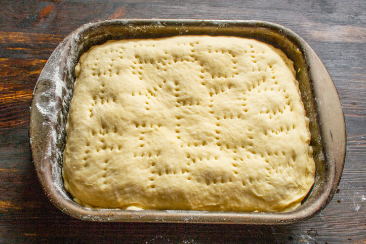 Letting the Assembled Pie Proof Before Baking The assembled cabbage pie covered with a kitchen towel, proofing.