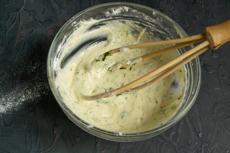 Mixing Dill into the Smooth Pirozhki Batter Stirring freshly chopped dill into the smooth batter for the savory pies.