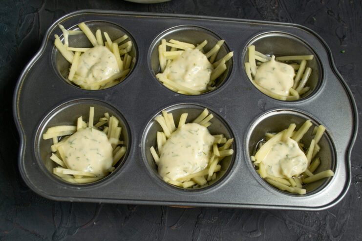Adding a Batter Layer Over the Potatoes Spoon a thin layer of batter over the potatoes in the muffin tin cups.