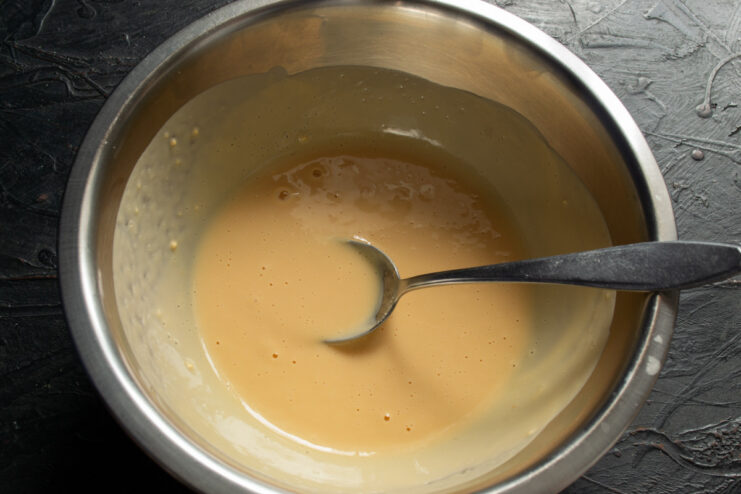 How to rehydrate egg powder for baking A bowl with egg powder being mixed with cold water to rehydrate it.