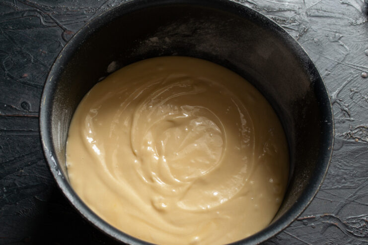 Pouring sponge cake batter into a baking pan Sponge cake batter being poured into a prepared baking pan.
