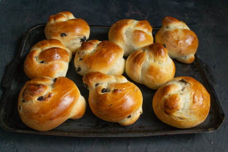 Step 13: Baking the plyushki until golden brown. A baking sheet with golden-brown plyushki baking inside a hot oven.