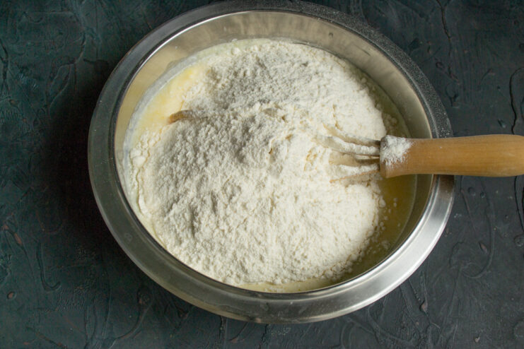 Step 4: Sifting all-purpose flour into the wet ingredients. Sifting all-purpose flour through a fine-mesh sieve into the bowl of wet ingredients.