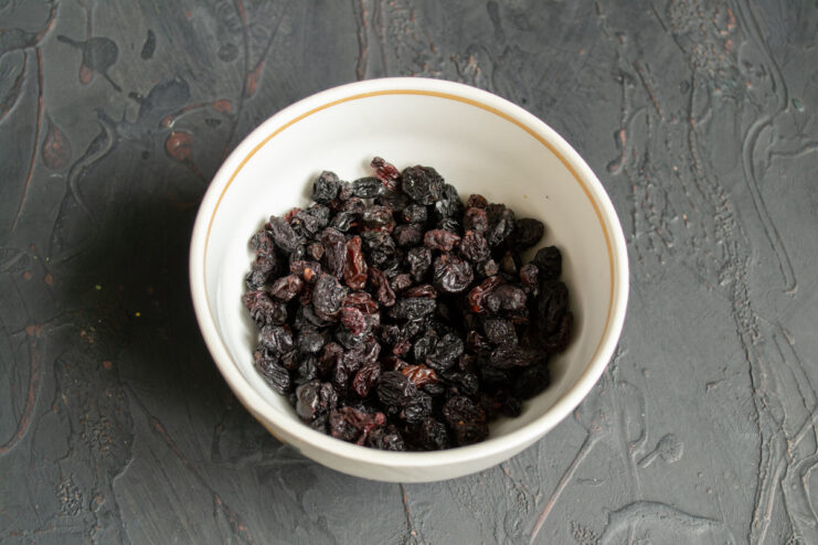 Step 6: Preparing the raisins by soaking them in hot water. A bowl of raisins soaking in hot water to plump them up before adding to the dough.