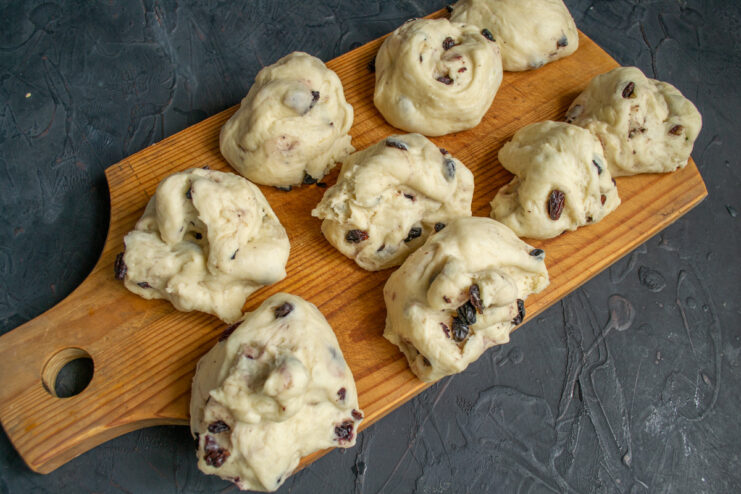 Step 8: Dividing the risen dough into equal portions. The risen dough punched down and divided into several equal-sized balls on a work surface.