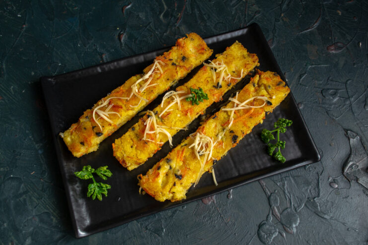 Serving Hot Fried Polenta with Cheese and Herbs Golden-fried polenta slices on a plate, topped with grated cheese and fresh herbs.
