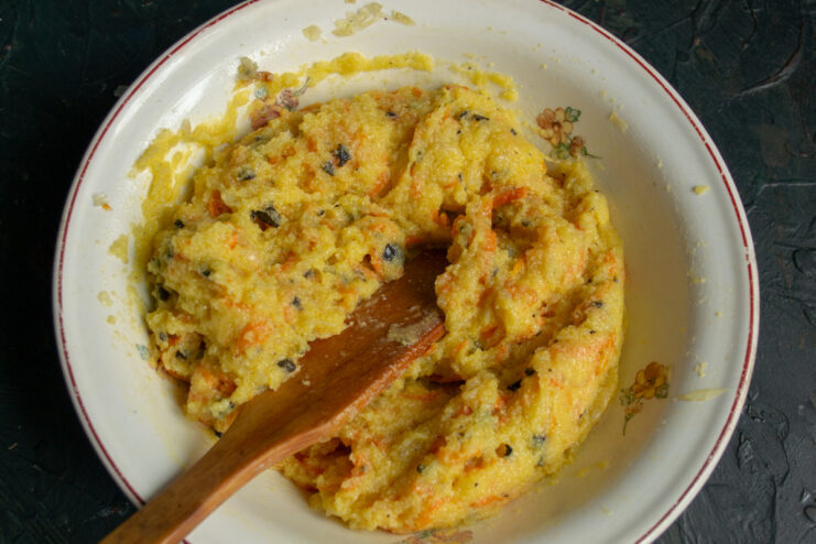 Stirring in Parmesan Cheese for a Rich Flavor Adding grated Parmesan cheese to the polenta mixture and stirring it in.