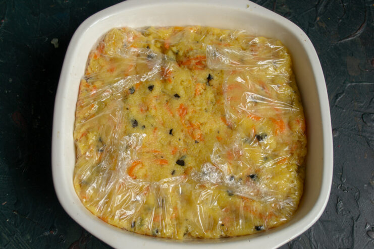 Spreading Polenta in a Dish to Set Spreading the hot polenta mixture into a plastic-wrap-lined dish to cool and set.