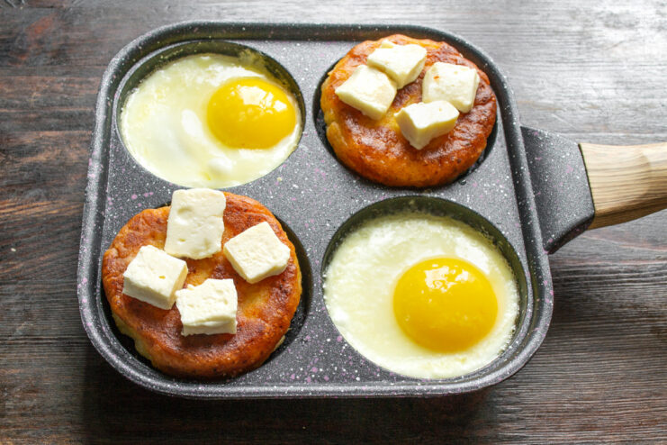 Flipping Oladyi to Melt the Cheese on Top The oladyi are flipped over, now with melted cheese on top.