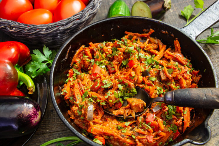A bowl of freshly made eggplant ragout with walnuts, garnished with fresh herbs.