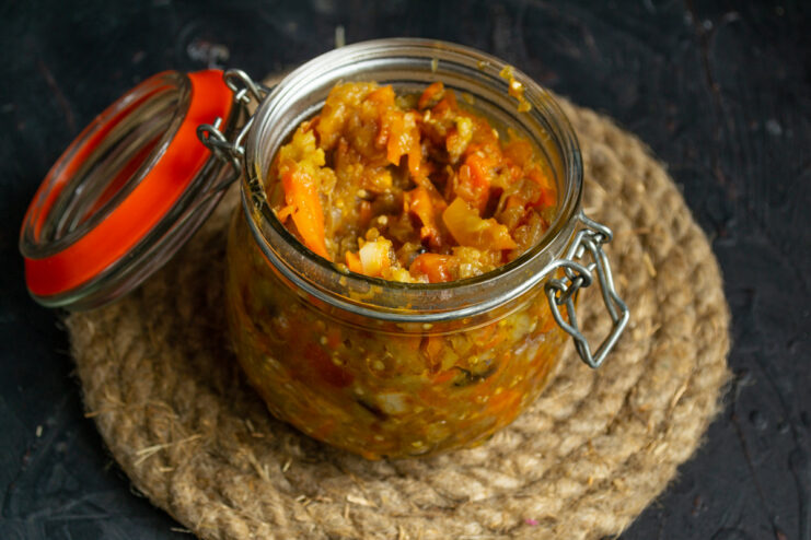 Canning the Roasted Vegetable Ragout for Long-Term Storage Hot roasted vegetable ragout being packed into a clean glass jar for canning.